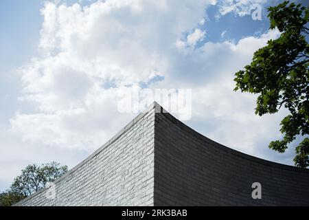 Curved corner of a brick wall, pointing to the sky. Stock Photo
