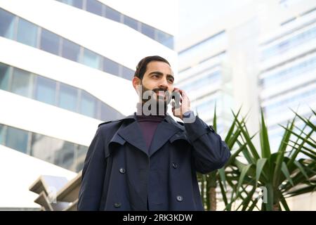 Muslimischer Geschäftsmann, der mit dem Handy spricht. Ein arabischer Geschäftsmann, der mit dem Handy spricht Stockfoto