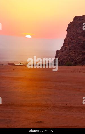 Jordanien, Wadi Rum Sonne scheint über dem Horizont, Sonnenaufgang in der Wüste, Camp-Zelte Stockfoto