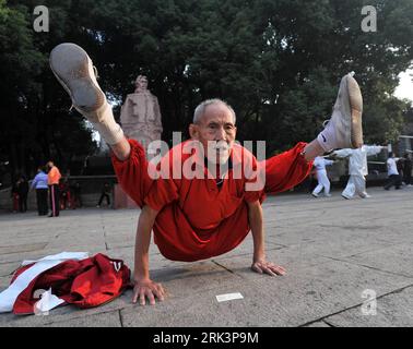 Bildnummer: 53543883 Datum: 19.10.2009 Copyright: imago/Xinhua (091020) -- WUHAN, 20. Oktober 2009 (Xinhua) -- der 91-jährige Xiao Qinglian führt seine Stunt-Show mit beiden Beinen über der Schulter durch, während er eine Münze mit dem Mund aufnimmt, indem er seinen Kopf zu Boden senkt, in einem Park in Wuhan, der zentralchinesischen Provinz Hubei, am 19. Oktober 2009. Der nicht-agenetische Mann hat die außergewöhnlichen körperlichen Übungen in den letzten 27 Jahren fortgesetzt, um den Körper fit zu halten. (Xinhua/Zhou Chao) (px) CHINA-WUHAN-NONAGENARIAN-PHYSICAL EXERCISE-STUNT(CN) PUBLICATIONxNOTxINxCHN Kurios Senioren gelenkig Kbdig xdp 2009 quer Stockfoto