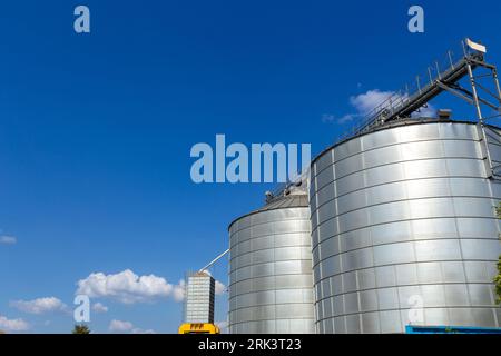 Moderner Getreideaufzug und Saatgutreinigungslinie. Silbersilos auf der Agro-Verarbeitungs- und Fertigungsanlage zur Lagerung und Verarbeitung Trocknung Reinigung von Stockfoto