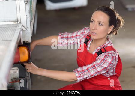 female mechanic working on industrial vehicle in garage Stock Photo