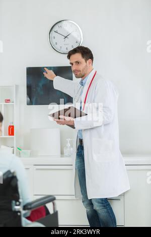 Junger männlicher Arzt, der eine mrt-Hirnuntersuchung liest und überprüft Stockfoto