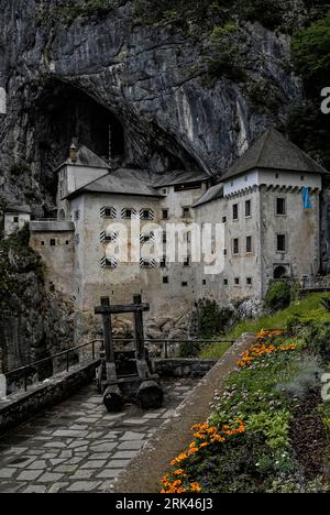 Predjama Castle, Predjamski grad or grad Predjama, an impregnable medieval marvel perched in the middle of a 123 metre-high cliff for more than 800 years in the village of Predjama in south-west Slovenia. Stock Photo