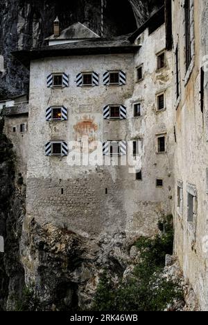 Ein verblasstes Wappen und das Datum 1570 an der Renaissance-Fassade der mittelalterlichen gotischen Burg Predjama, Predjamski Grad oder Grad Predjama, im Dorf Predjama im Südwesten Sloweniens. Stockfoto