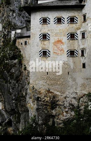 Verblasstes Wappen und das Datum von 1570 erinnern an den umfassenden Wiederaufbau der Burg Predjama im Stil der Renaissance im Südwesten Sloweniens, einer uneinnehmbaren mittelalterlichen gotischen Festung, die in der Mündung einer Höhle errichtet wurde. Stockfoto