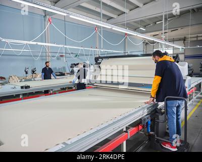 Mehrere Nähmaschinen. Maßgeschneiderte Branche. jean Making Factory. jean-Nähen. Arbeiter, der mit Nähmaschinen arbeitet, um Jeans zu nähen. Stockfoto