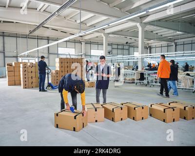 Mehrere Nähmaschinen. Maßgeschneiderte Branche. jean Making Factory. jean-Nähen. Arbeiter, der mit Nähmaschinen arbeitet, um Jeans zu nähen. Stockfoto