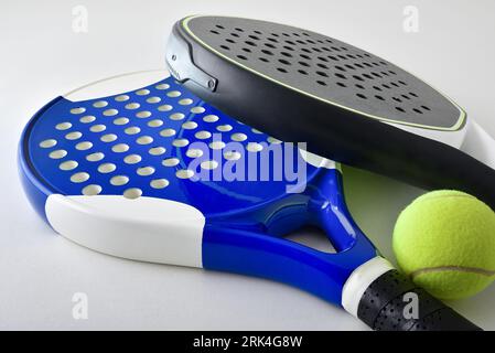 Background with two blue and black paddle rackets on a white table with ball. Elevated view. Stock Photo