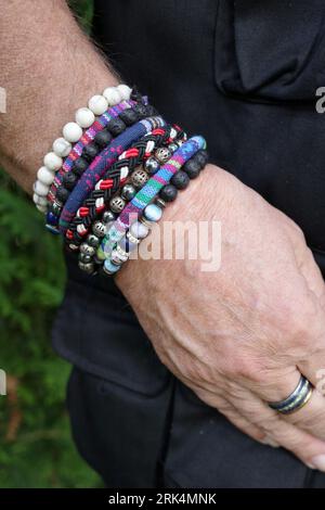 Male hand with a row of bracelets, breaded bracelets and ethnic hippie style Stock Photo