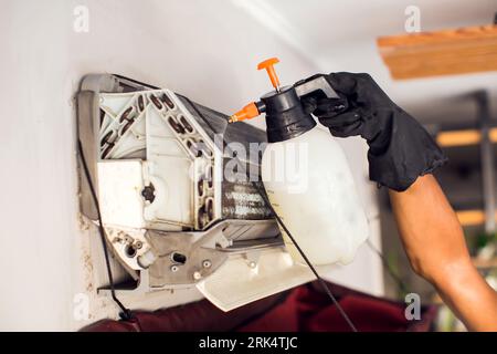 Reinigung der Klimaanlage durch Spritzen. Man wäscht einen speziellen Schaum für die Reinigung der Klimaanlage ab. Das Klimaanlagenkonzept wird beibehalten. Stockfoto