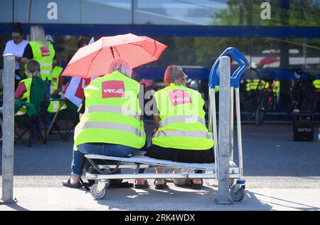 Hannover, Deutschland. August 2023. Mitarbeiter im niedersächsischen Einzelhandel sitzen bei einem Warnstreik vor dem Ikea Store Expo-Park auf einem Einkaufswagen. Die gewerkschaft Verdi hat die Beschäftigten im Einzelhandel erneut aufgefordert, sich an einem Warnstreik zu beteiligen. Betroffen sind die Ikea Stores Expo-Park und Großburgwedel bei Hannover, Ikea Braunschweig, das Modegeschäft Primark Hannover, zwei H&M Stores in Hannover und das Lebensmittelgeschäft Kaufland Laatzen. Quelle: Julian Stratenschulte/dpa/Alamy Live News Stockfoto