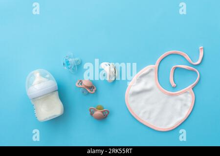 Top-down view of baby essentials with pacifiers on soft blue, offering ample space Stockfoto
