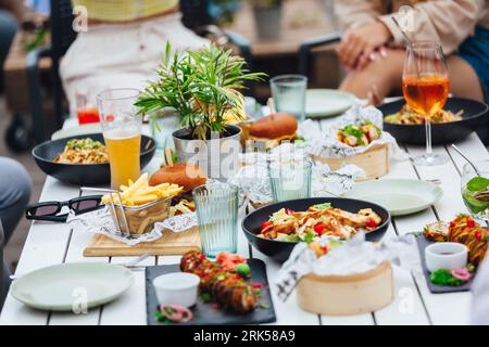 Eine Gruppe von Menschen, die im Sommer gemeinsam in einem Restaurant im Freien essen Stockfoto