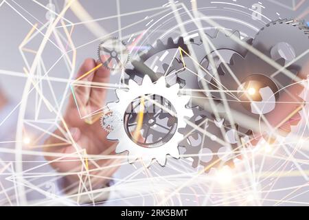 Eine Geschäftsfrau, die eine Reihe von Zahnrädern als Konzept für Unternehmen, Technologie und innovative Ideen präsentiert Stockfoto