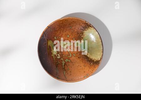 Japanese-style pottery dish, top view angle on a white wooden table. Stock Photo