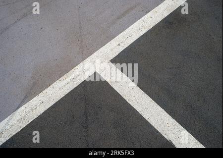 Gestrichene weiße Linien auf einem Parkplatz auf Asphalt, Parkplätze. Stockfoto