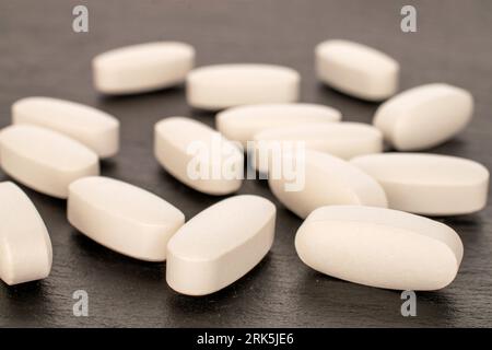 Several medical pills  on slate stone, macro. Stock Photo