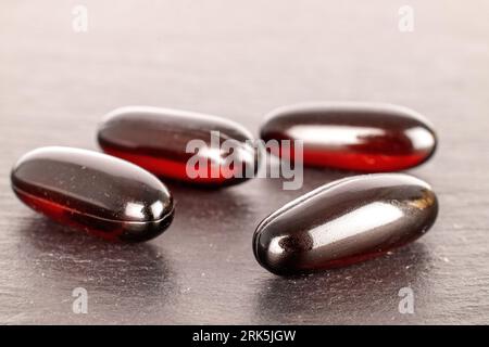 Several medical pills  on slate stone, macro. Stock Photo