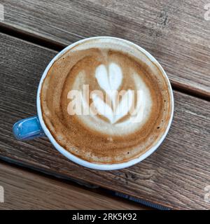 Eine Draufsicht auf eine Tasse Kaffee auf einem Holztisch Stockfoto