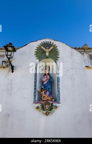 Eine vertikale Statue der Jungfrau in einer Nische in Ferragudo, Lagoa, Algarve, Portugal Stockfoto