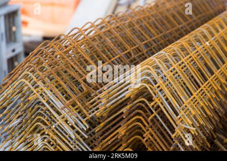 Auf einer Baustelle gelagerter Stahlbau mit etwas Rost zur späteren Verstärkung von Betonkonstruktionen in einem Gebäude Stockfoto