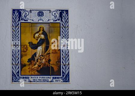 Eine Nahaufnahme von Mosaikfliesen an einer weißen Wand eines Gebäudes Stockfoto