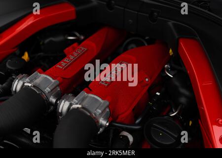 A close-up view of a Ferrari red engine, showcasing its intricate mechanical details Stock Photo