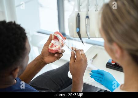 Der Mann, der Modellzähne in der Zahnheilkunde putzt Stockfoto