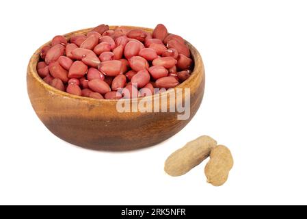 Shelled peanuts in a wooden bowl and in shell on a white background. Copy space. Stock Photo