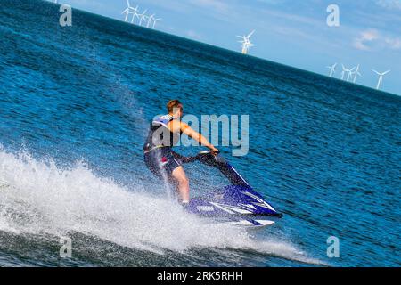 Ein Mann fährt mit dem Jet-Ski über ein ruhiges Gewässer Stockfoto