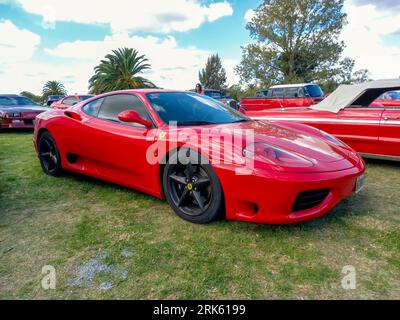 Red Sport Ferrari 360 Modena Coupe Berlinetta in einem Park. Natur, Gras, Bäume. CAACMACH 2023 Oldtimer-Show. Stockfoto