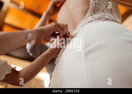 Eine junge Frau, die ein weißes Brautkleid mit komplizierten Details trägt Stockfoto