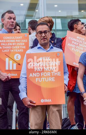 London, Großbritannien. August 2023. Seniorärzte halten Plakate zur Unterstützung einer fairen Bezahlung an der Kasse außerhalb des Universitätskrankenhauses. Die Ärzte versammelten sich an der britischen Ärztekammer (BMA), während die Berater des NHS (National Health Service) ihren Streik über die Bezahlung fortsetzen. Quelle: SOPA Images Limited/Alamy Live News Stockfoto