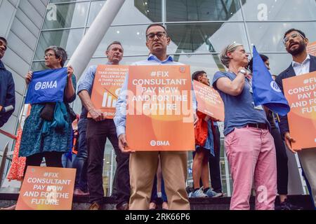 London, Großbritannien. August 2023. Seniorärzte halten Plakate zur Unterstützung einer fairen Bezahlung an der Kasse außerhalb des Universitätskrankenhauses. Die Ärzte versammelten sich an der britischen Ärztekammer (BMA), während die Berater des NHS (National Health Service) ihren Streik über die Bezahlung fortsetzen. Quelle: SOPA Images Limited/Alamy Live News Stockfoto