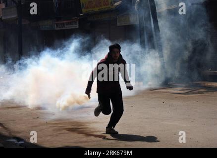 Bildnummer: 53808246  Datum: 20.02.2010  Copyright: imago/Xinhua (100220) -- SRINAGAR, Feb. 20, 2010 (Xinhua) -- A Kashmiri Muslim protestor runs to throw back a teargas shell to Indian police during an anti-Indian protest in Srinagar, summer capital of Indian-controlled Kashmir, Feb. 20, 2010. Indian police in Srinagar on Saturday used tear smoke shells to disperse Kashmiri protestors during a strike called by the region s hardline faction of the Hurriyat Conference against alleged human rights violations on Kashmiri by Indian security forces. (Xinhua/Javed Dar) (zcq) (4)KASHMIR-SRINAGAR-PROT Stock Photo