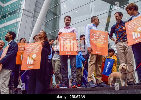 London, Großbritannien. August 2023. Seniorärzte halten Plakate zur Unterstützung einer fairen Bezahlung an der Kasse außerhalb des Universitätskrankenhauses. Die Ärzte versammelten sich an der britischen Ärztekammer (BMA), während die Berater des NHS (National Health Service) ihren Streik über die Bezahlung fortsetzen. (Foto: Vuk Valcic/SOPA Images/SIPA USA) Credit: SIPA USA/Alamy Live News Stockfoto