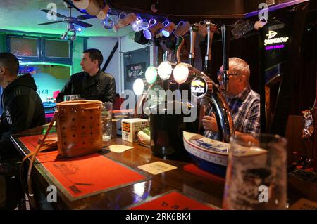 Leute, die ein großes Sportereignis im Fernsehen in einem lokalen Pub beobachten Stockfoto