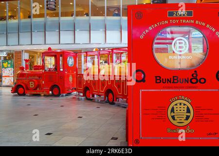 Oita, Japan - November 26 2022: Der berühmte japanische Spielzeugzug, Bun Bun Go, verkehrte in der zentralen Halle des Bahnhofs Oita Stockfoto