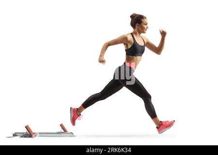 Profilaufnahme in voller Länge eines jungen weiblichen Laufsprints aus Startblöcken, isoliert auf weißem Hintergrund Stockfoto