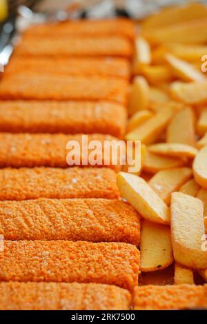 Ein Teller mit goldbraunen knusprigen Kartoffeln und Fisch nebeneinander, bereit zum Genießen Stockfoto