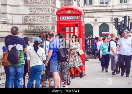 London, England, Großbritannien. August 2023. Touristen warten auf Selfies neben einer Telefonbox auf dem Parliament Square. BT hat 1000 rote Telefonboxen für die „Adoption“ in Großbritannien für jeweils nur Â £ vor dem 100. Jahrestag zur Verfügung gestellt. Die originale Inkarnation des berühmten roten Kiosks, der K2, wurde 1924 vom Architekten Sir Giles Gilbert Scott entworfen und als die Nutzung öffentlicher Telefone im Laufe der Jahre abnahm, bot BT die Möglichkeit, die Kioske verschiedenen Organisationen, Gemeinschaften und Einzelpersonen zu nutzen. (Bild: © Vuk Valcic/ZUMA Press Wire) NUR REDAKTIONELLE VERWENDUNG Stockfoto