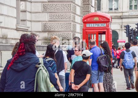 London, Großbritannien. August 2023. Touristen warten auf Selfies neben einer Telefonbox auf dem Parliament Square. BT hat 1000 rote Telefonboxen für die „Adoption“ in Großbritannien für jeweils nur 1 £ vor dem 100. Jahrestag zur Verfügung gestellt. Die originale Inkarnation des berühmten roten Kiosks, der K2, wurde 1924 vom Architekten Sir Giles Gilbert Scott entworfen und als die Nutzung öffentlicher Telefone im Laufe der Jahre abnahm, bot BT die Möglichkeit, die Kioske verschiedenen Organisationen, Gemeinschaften und Einzelpersonen zu nutzen. Quelle: Vuk Valcic/Alamy Live News Stockfoto