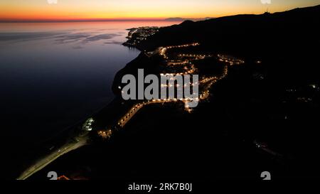 Dieses Luftbild nimmt eine atemberaubende Aussicht auf eine Landschaft auf, die bei Nacht mit Licht beleuchtet wird Stockfoto