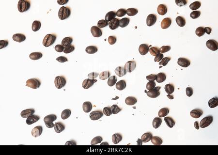 Eine weiße Oberfläche mit frisch verschütteten Kaffeebohnen Stockfoto