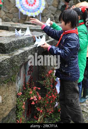 Bildnummer: 53910694  Datum: 01.04.2010  Copyright: imago/Xinhua (100402) -- XIUNING, April 2, 2010 (Xinhua) -- Two young pioneers lay on the self hand-folded paper cranes to pay tribute to the Monument to the Unnamed Revolutionary Martyrs, in Xiuning County, east China s Anhui Province, April 1, 2010. More than 200 local from all walks of life gather at the Monument to the Unnamed Revolutionary Martyrs in a large memorial ceremony to express their profound memory of grief against drizzling, as the thousand-year-old tomb sweeping day, Qingming festival which falls on April 5 this year, draws n Stock Photo