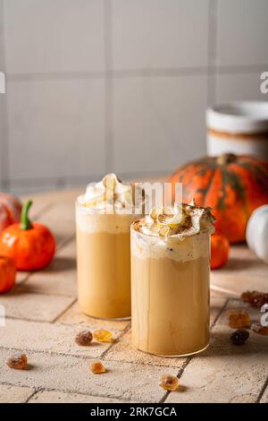 Herbstlicher Kürbis-Latte mit Schlagsahne und Zimt auf hellem Hintergrund Stockfoto