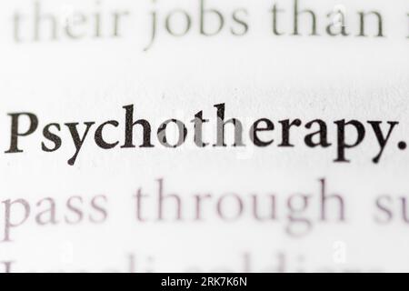Medizinisches Psychologiekonzept - Nahaufnahme einer Hand, die ein Papier hält, auf dem das Wort „Psychotherapie“ steht, was auf eine Behandlung psychischer Erkrankungen hinweist Stockfoto