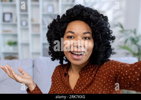 Nahaufnahme. Porträt einer jungen afroamerikanischen Frau, die während eines Videoanrufs zu Hause mit der Kamera spricht. Stockfoto