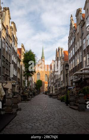 Ein atemberaubendes Bild der historischen Altstadt von Danzig, Polen, beleuchtet von den warmen Orangetönen des frühen Sonnenaufgangs Stockfoto